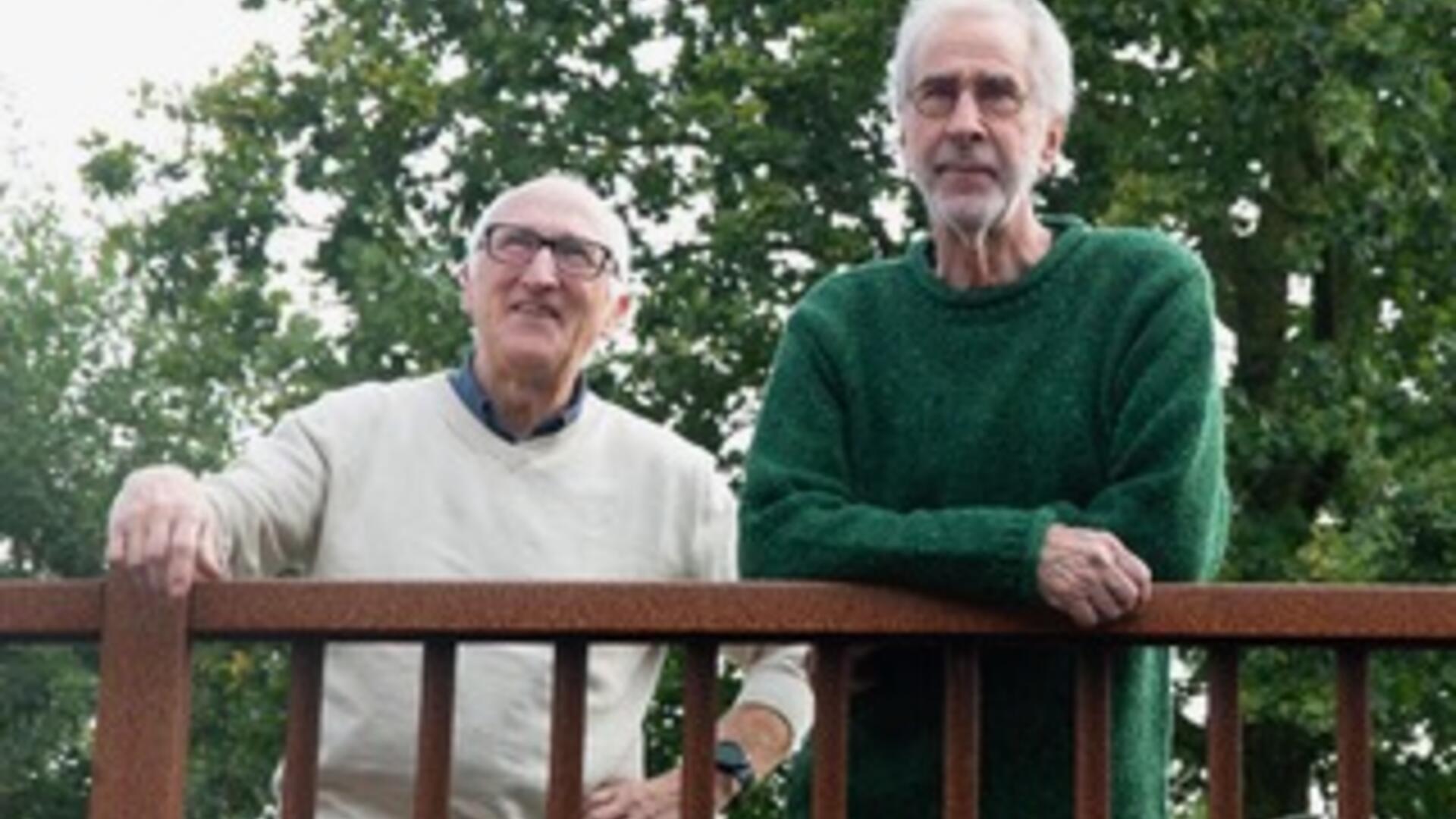 Luut en Dirk voor de oude steenfabriek Rusthoven in Loppersum. Ze staan voor een oud eiken hek. Ruïne steenoven is zichtbaar op achtergrond.